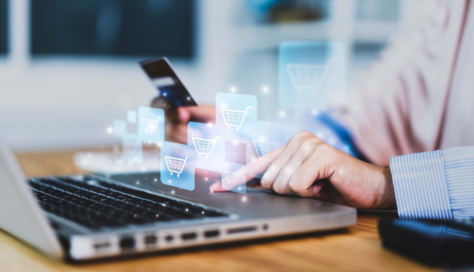 A person uses a laptop and holds a credit card, with digital shopping cart icons overlaid, representing online commerce and e-commerce.