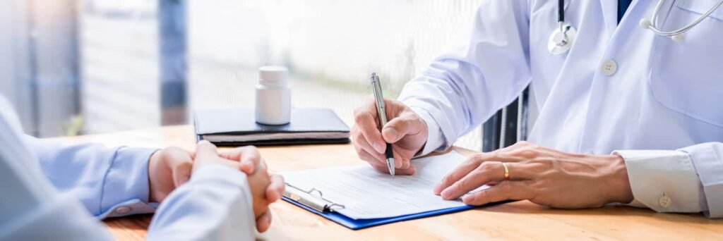 Crafting Engaging Healthcare Content: Tips for Health and Wellness Companies A doctor in a white coat writes content on a medical form at a desk, while a patient sits across with hands folded; a bottle of pills is on the table.