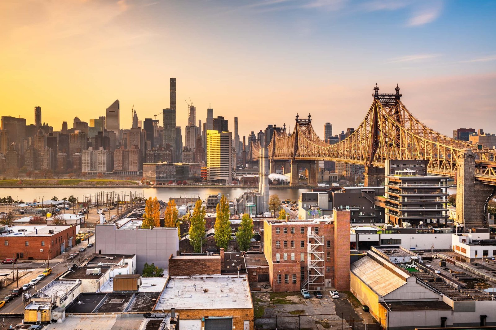 View of the Queensboro Bridge spanning the East River with the New York City skyline in the background during sunset, capturing the vibrant spirit that inspires local creatives like Queens Web Design.