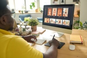 Person editing multiple photos of a model on a desktop computer using a graphics tablet at a desk in a well-lit office, perfect for Website Design NYC projects.