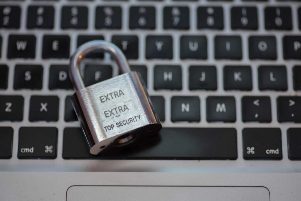 A metal padlock labeled "EXTRA EXTRA TOP SECURITY" rests on a laptop keyboard.