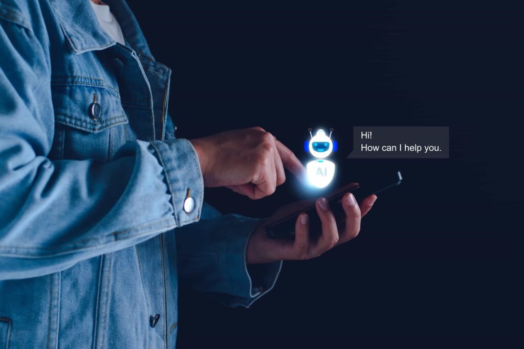 A person in a denim jacket uses a smartphone, interacting with a digital AI chatbot saying, “Hi! How can I help you.” on a dark background. How I’m Preparing WordPress Sites for the AI Search Revolution in NYC web design and SEO.