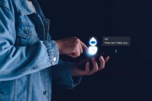 A person in a denim jacket uses a smartphone, interacting with a digital AI chatbot saying, “Hi! How can I help you.” on a dark background. How I’m Preparing WordPress Sites for the AI Search Revolution in NYC web design and SEO.