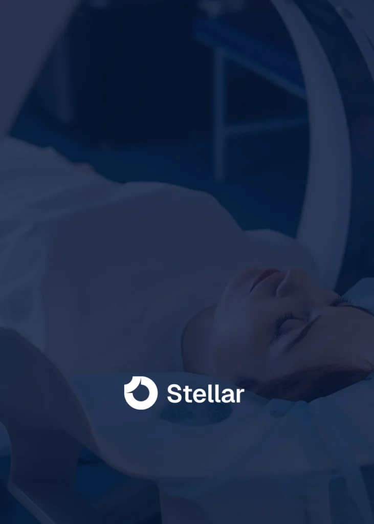 Person lying on a medical imaging bed with the Stellar logo displayed in the foreground, expertly captured by a top Medical Web Designer in NYC.