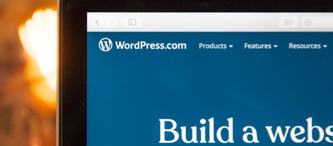 Close-up of a computer screen displaying the WordPress.com website. The text on the screen reads, "Build a website, build a movement.